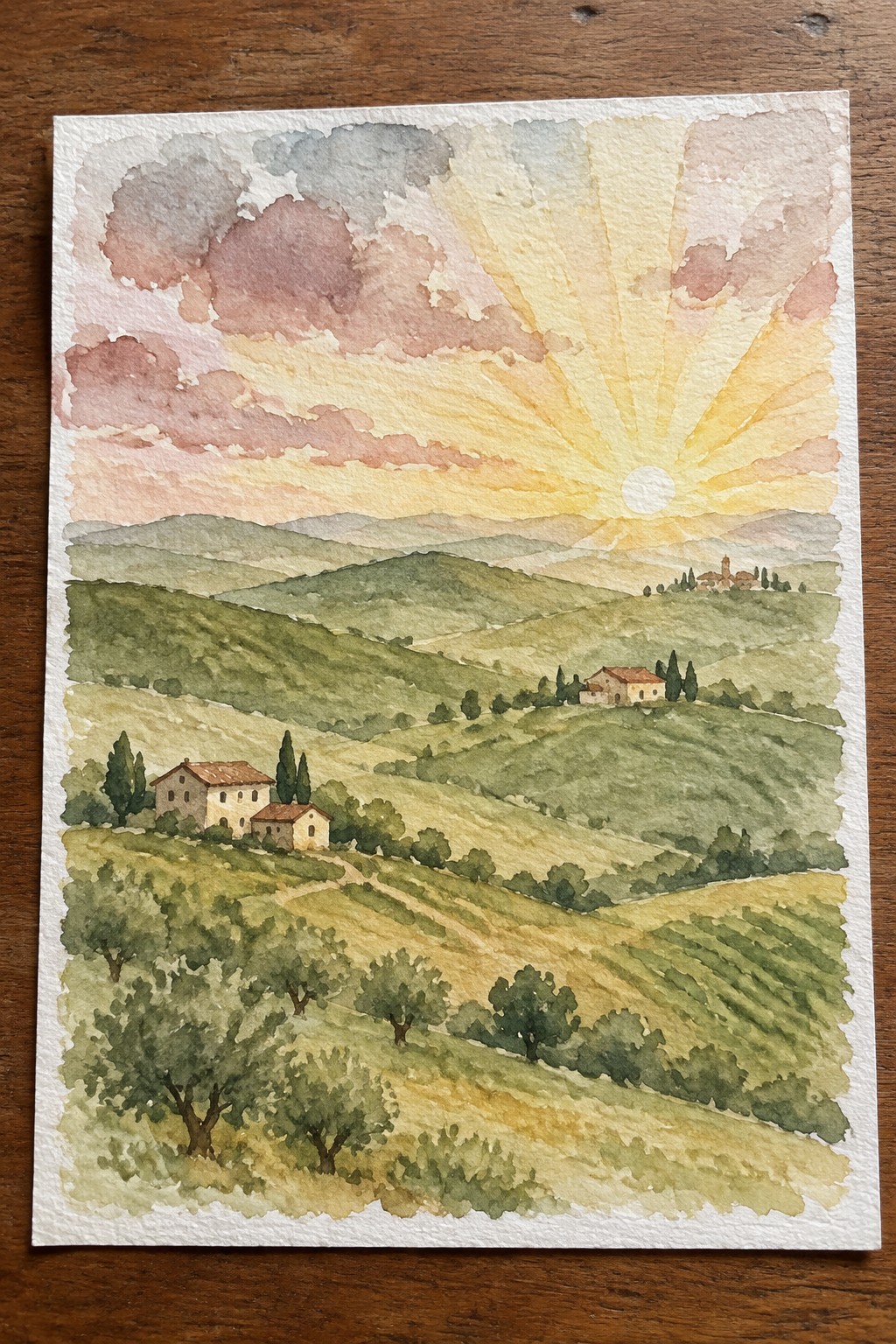 A watercolor painting of rolling green hills with farmhouses and trees under a bright sunset sky with radiating rays.