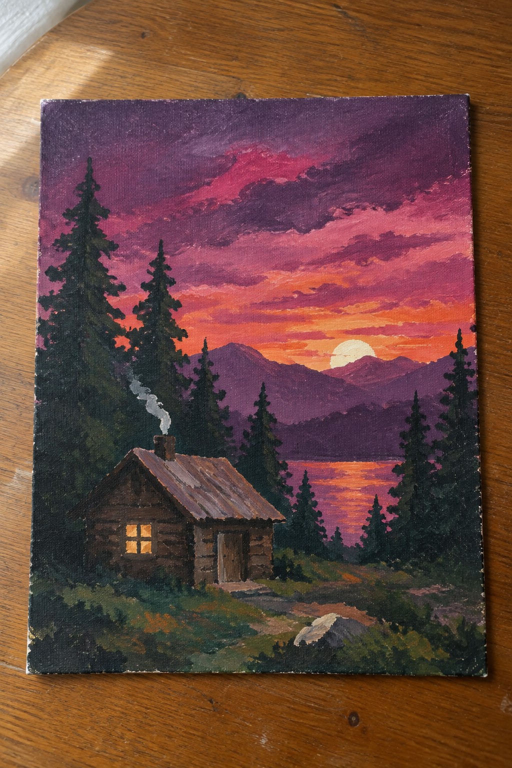 Log cabin with glowing window and smoking chimney by orange sunset lake