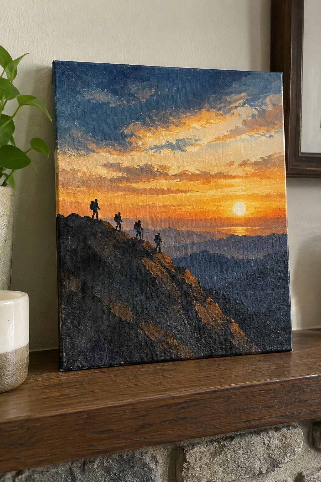 Painting of four silhouetted hikers on rocky ridge under vibrant orange sunset sky