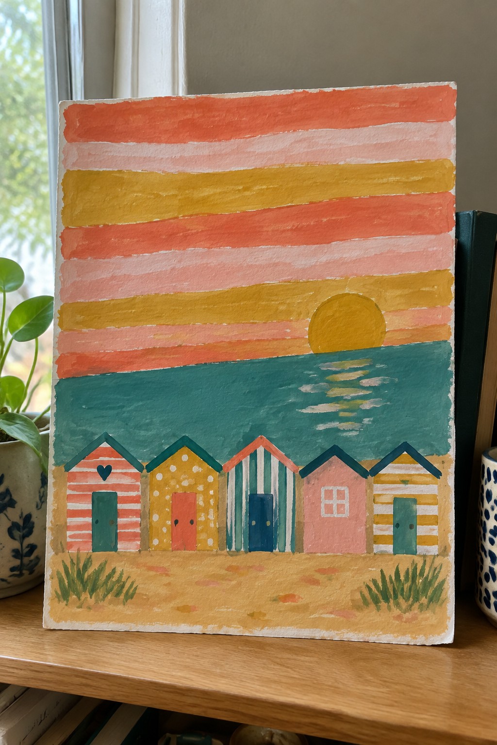 Colorful watercolor beach huts under striped sunset sky with yellow sun over teal sea