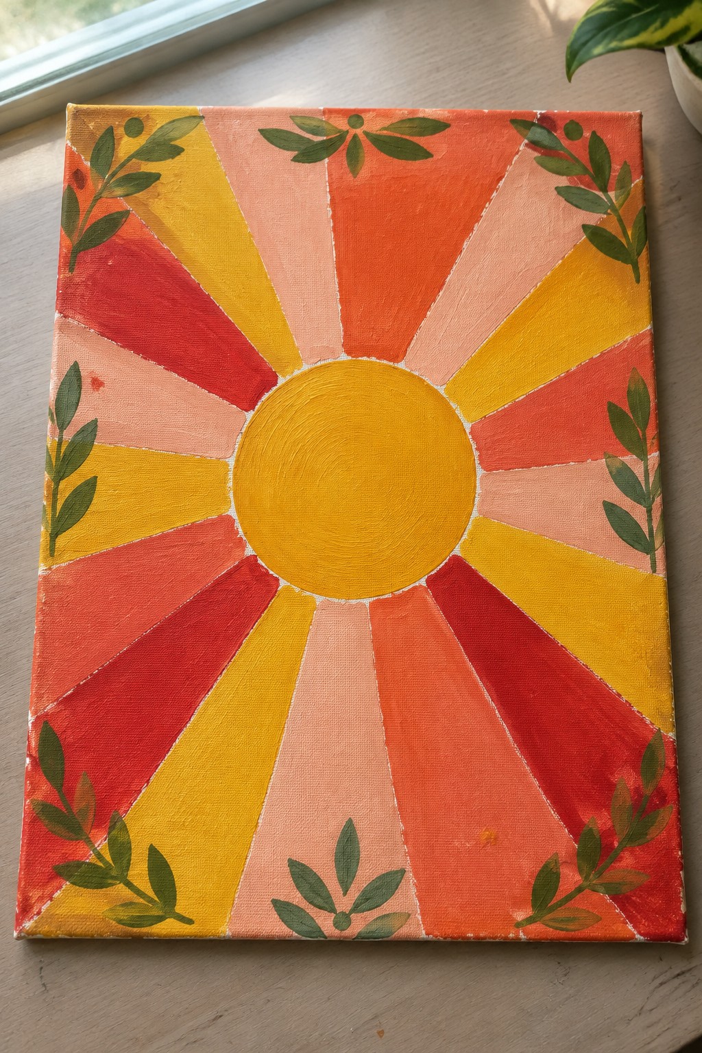 Vibrant canvas painting of yellow sun with radiating orange-red rays and green leafy branches.